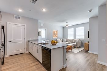 A modern kitchen with a large island and a dining area.